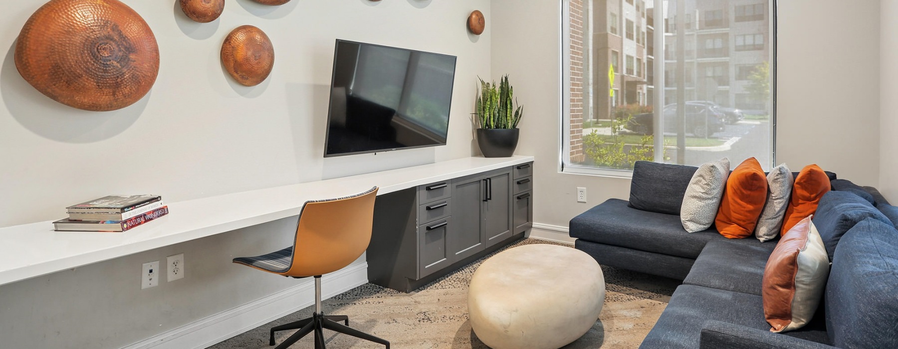 well lit lounge with couches and desk